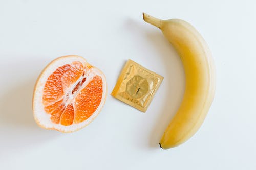 橘子和香蕉之间的避孕套 · 免费素材图片