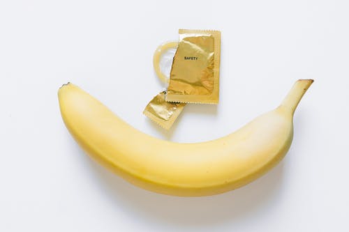 黄色香蕉旁边的避孕套 · 免费素材图片