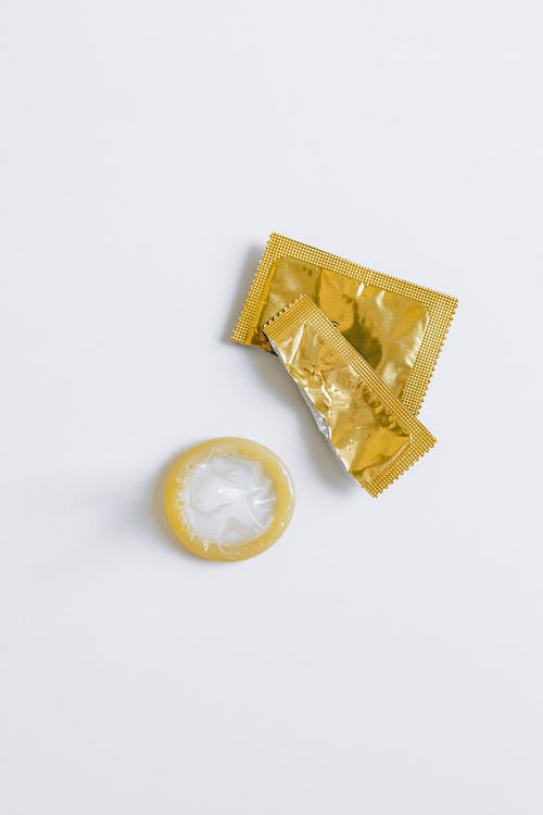 白色表面上解开的避孕套 · 免费素材图片