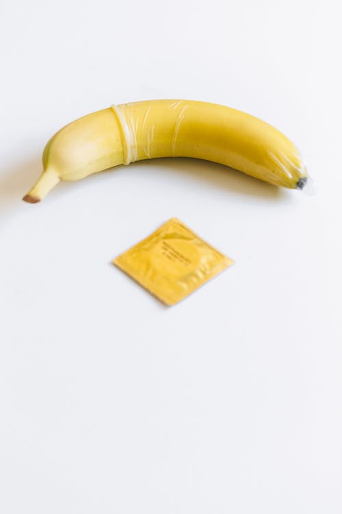黄色香蕉旁边的避孕套 · 免费素材图片