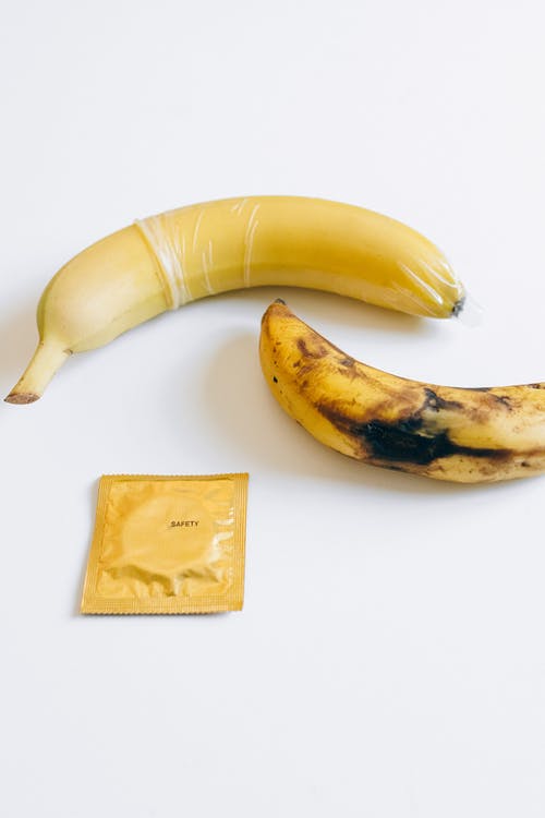 香蕉旁边的避孕套 · 免费素材图片