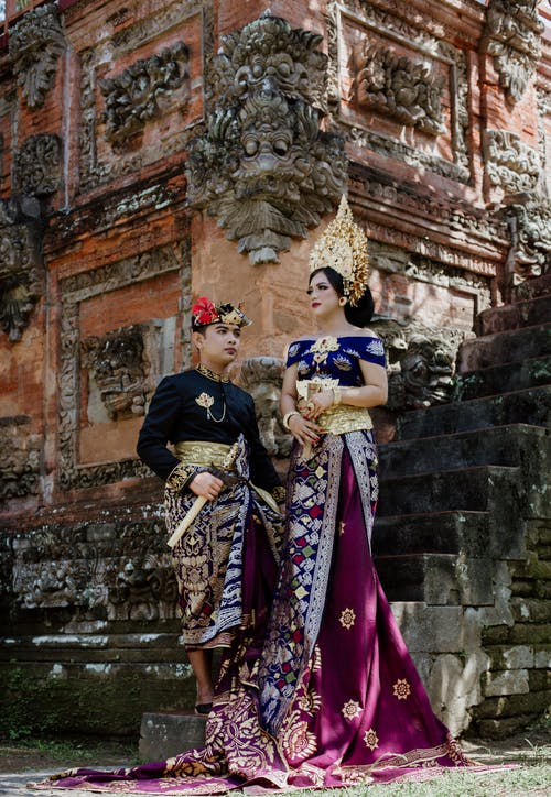穿着传统服装的时髦种族夫妇在寺庙附近的台阶上 · 免费素材图片