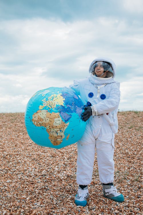 抱着一个地球仪的宇航员 · 免费素材图片
