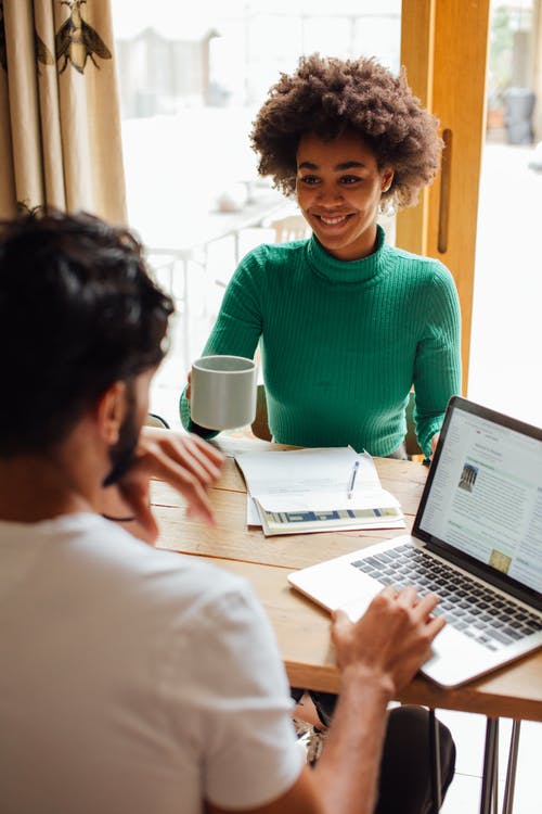 使用macbook Pro的绿色圆领衬衫的男人 · 免费素材图片