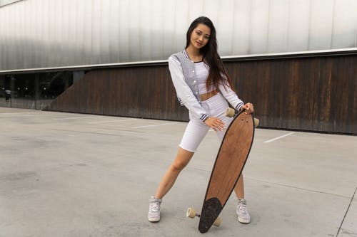 时尚年轻的亚洲女性千禧年站在木制退潮的街道上 · 免费素材图片