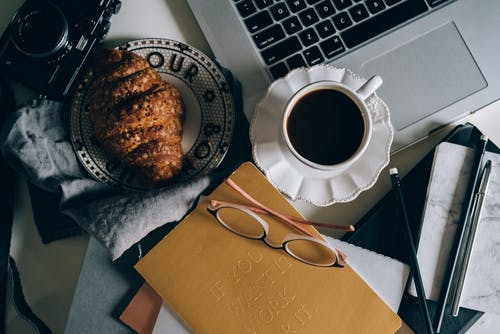 棕色纸袋旁边的白色和蓝色陶瓷碟上的白色陶瓷杯 · 免费素材图片