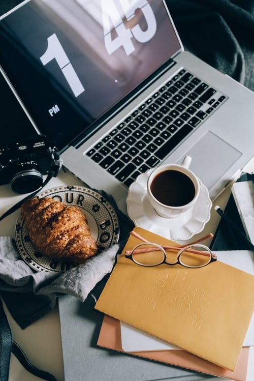 黑色和银色便携式计算机旁边的白色陶瓷杯 · 免费素材图片
