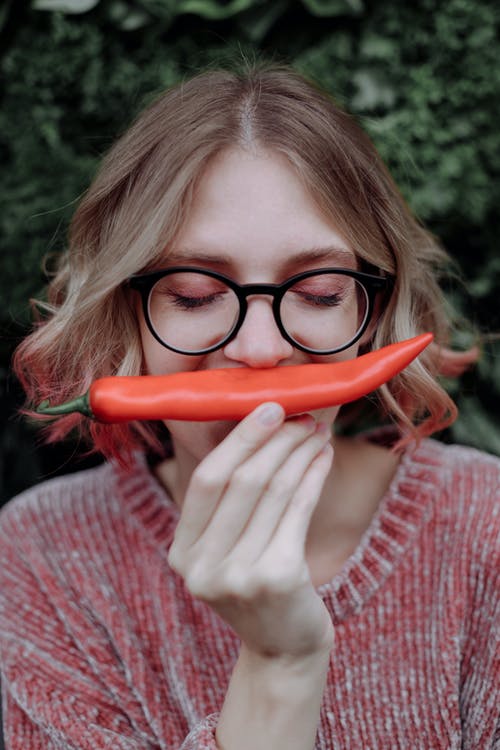 穿黑框眼镜的红色毛衣的女孩 · 免费素材图片