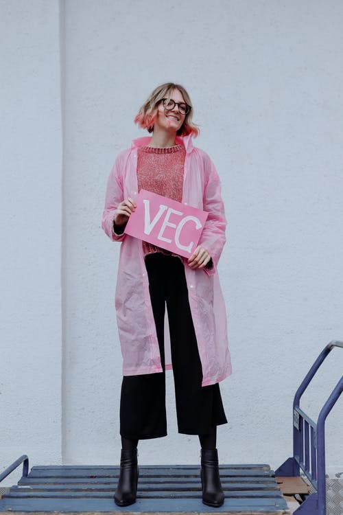 粉红色的长袖衬衫和黑色的裤子，站在白墙上的女人 · 免费素材图片