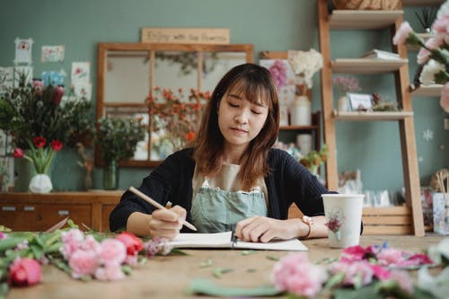 集中在笔记本中的亚洲女人绘图 · 免费素材图片