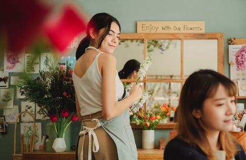 在时尚店制作花束的微笑花店 · 免费素材图片