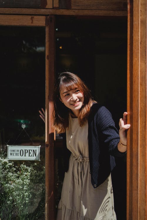 围裙开幕商店门的微笑的亚裔妇女 · 免费素材图片