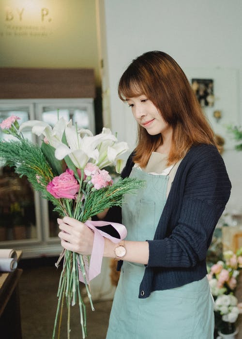 美满的亚裔女子和在商店里的花束 · 免费素材图片