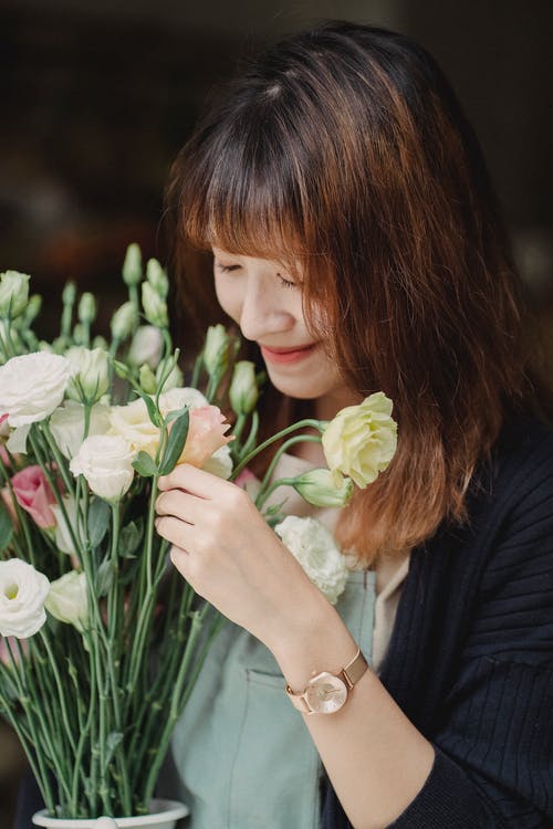 种族微笑的妇女嗅到的花束新鲜花 · 免费素材图片