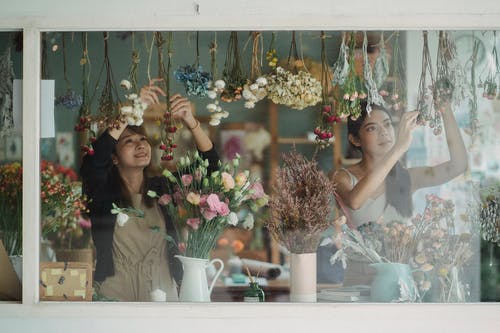 快乐多样的女性花店，装饰着鲜花的商店橱窗 · 免费素材图片