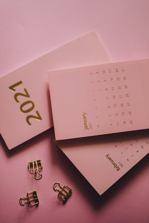 现代日历附近粉红色的背景上的金属夹 · 免费素材图片