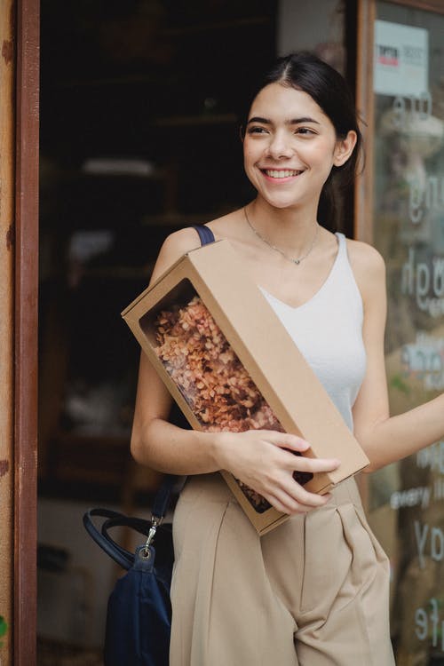 小包装店附近的幸福女人 · 免费素材图片