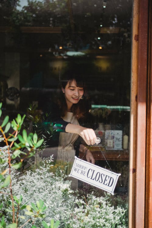 女性花店挂在门上的标志 · 免费素材图片