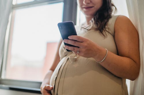 在智能手机上匿名孕妇发短信 · 免费素材图片