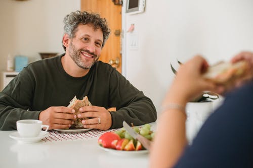 性格开朗的大胡子的男人和妻子一起吃早餐 · 免费素材图片