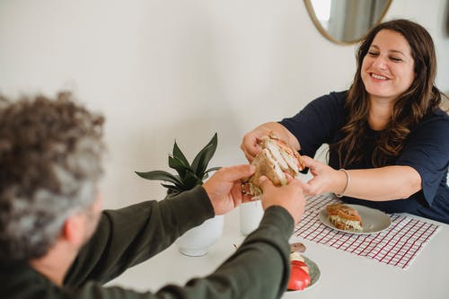 幸福的夫妇，在家里吃美味的三明治 · 免费素材图片