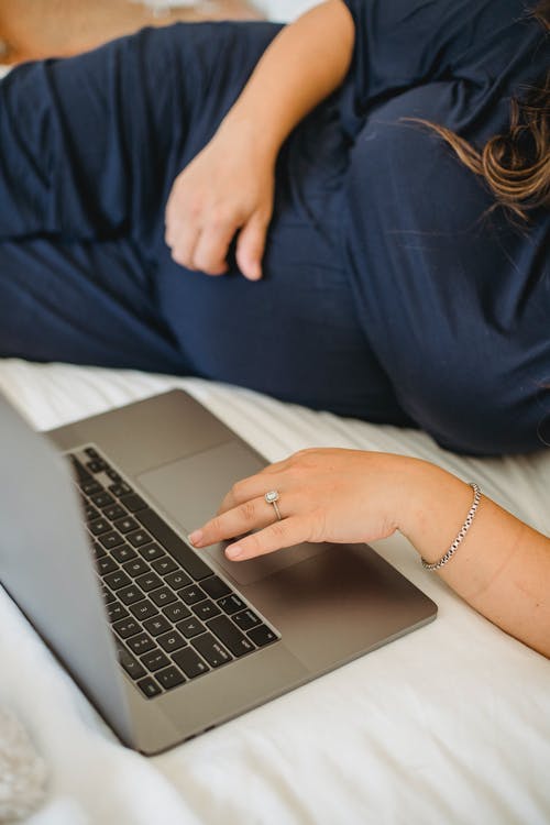 在卧室里的笔记本电脑上上网作物预期女人上网 · 免费素材图片