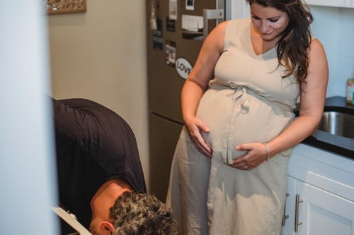 孕妇看着丈夫时摸腹部 · 免费素材图片
