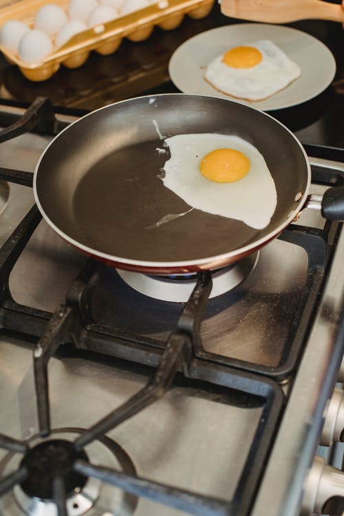 厨房的锅和盘子里的煎的鸡蛋 · 免费素材图片