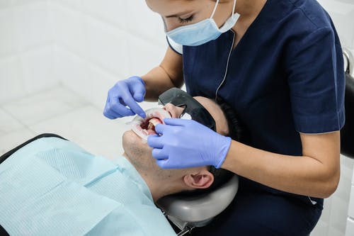 牙医在诊所治疗客户的牙齿 · 免费素材图片