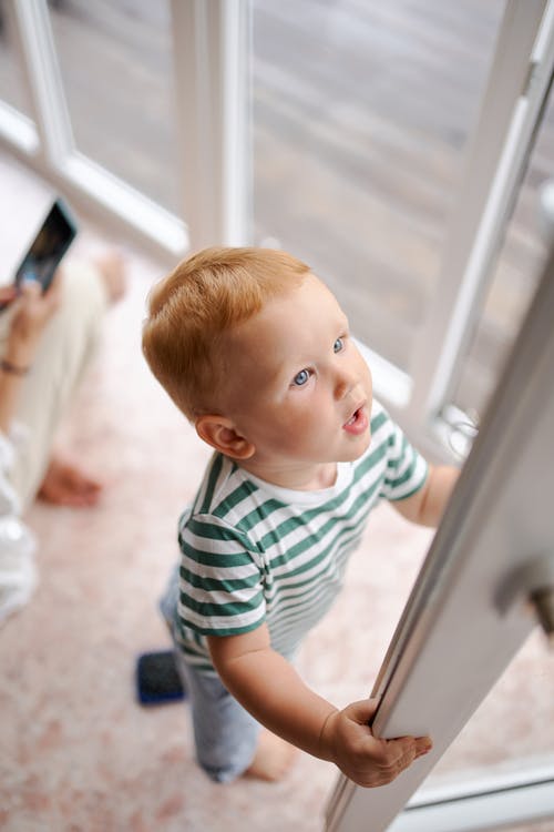 小男孩穿着休闲服开门 · 免费素材图片