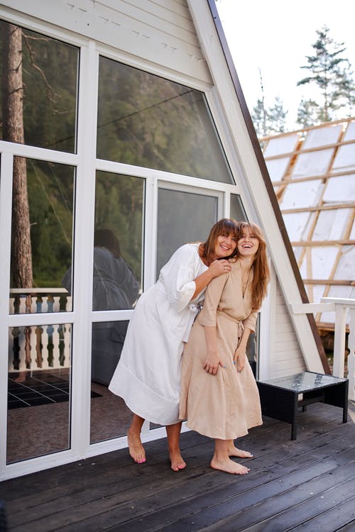 性格开朗的妇女，在开放的露台上拥抱 · 免费素材图片