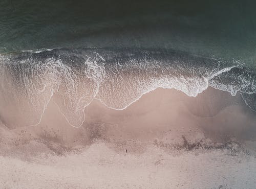 无人机视图挥舞着大海翻滚着沙滩 · 免费素材图片
