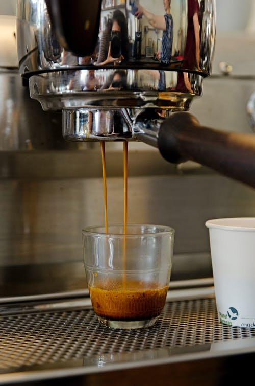 从咖啡机滴入杯中的咖啡 · 免费素材图片