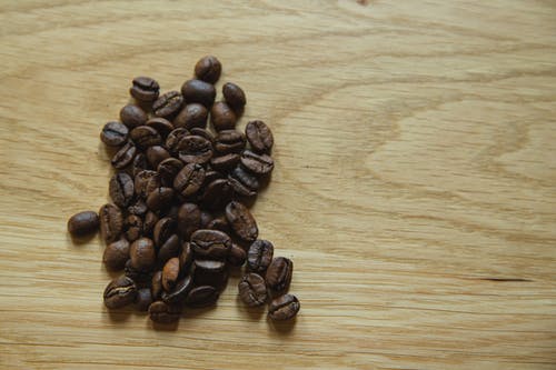 桌子的木质表面上的咖啡豆 · 免费素材图片