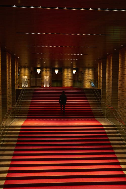 在红地毯的建筑物中的黑暗身影 · 免费素材图片
