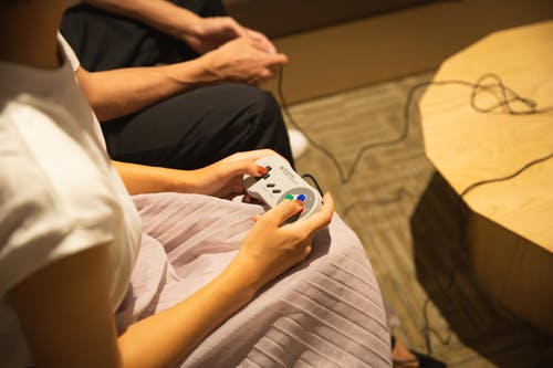 变得面目全非的夫妇在家里玩电子游戏与游戏手柄 · 免费素材图片