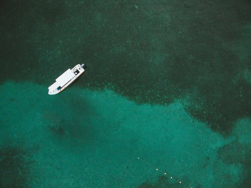 船漂浮在透明的水晶水上 · 免费素材图片