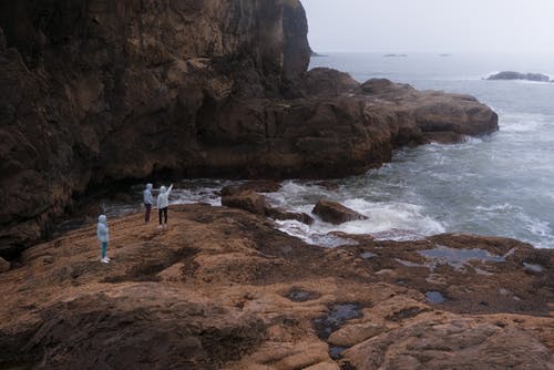 站在岩石海岸上的旅行者 · 免费素材图片