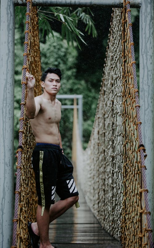 老吊桥上的赤膊亚洲男子 · 免费素材图片