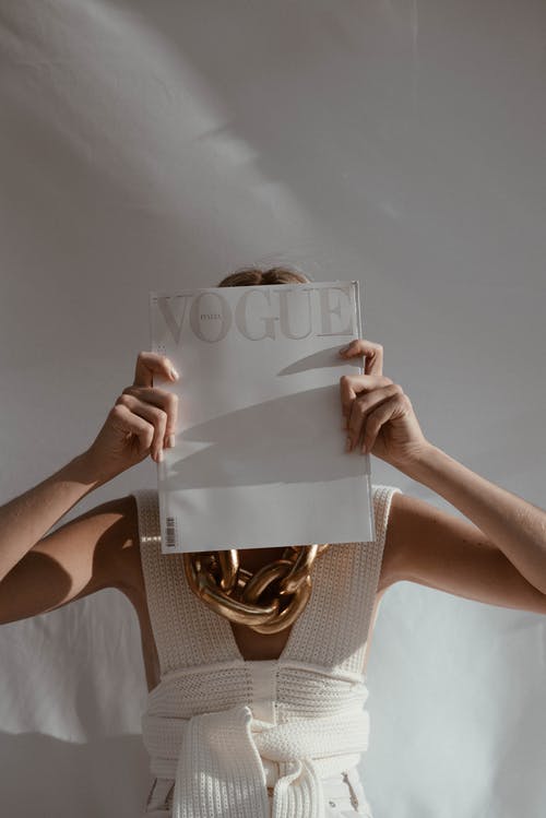 匿名的女人捂着脸与杂志 · 免费素材图片