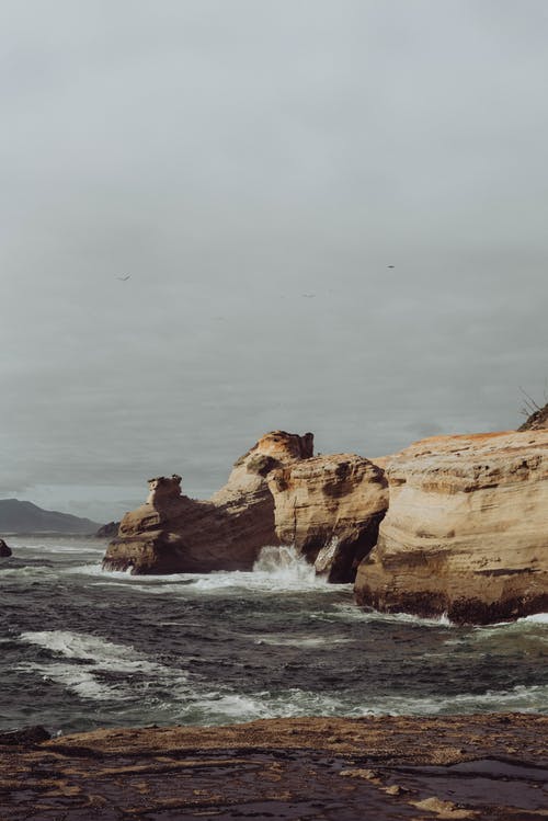 海浪之上的粗糙岩石峭壁 · 免费素材图片