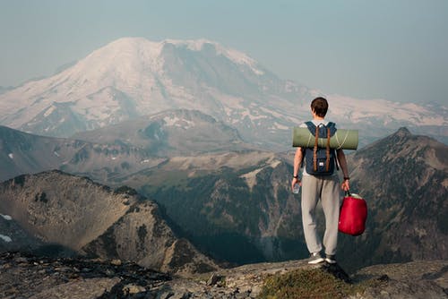站在山顶上的面目全非的背包客 · 免费素材图片