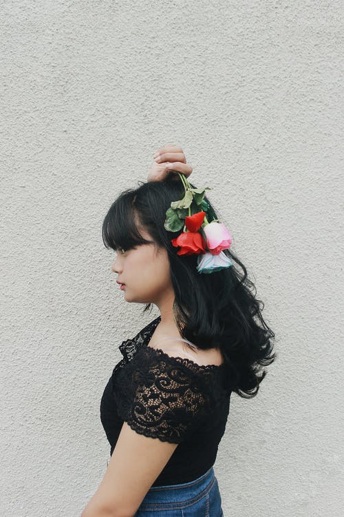 自信的民族女性少年与手中的精致玫瑰 · 免费素材图片