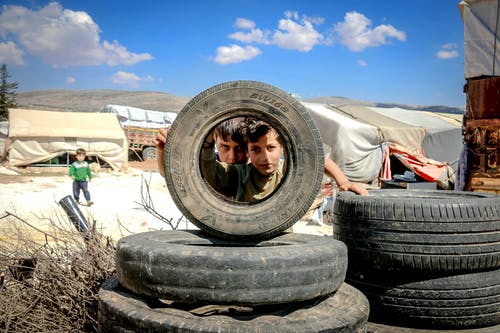 看通过车轮的男孩在贫民窟 · 免费素材图片