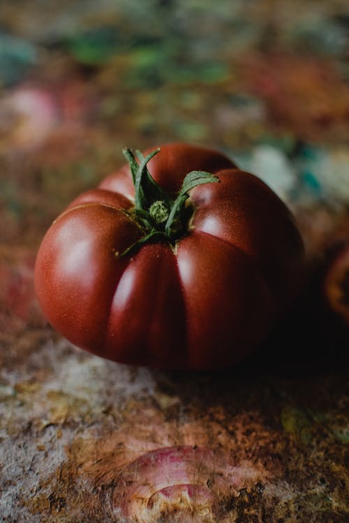 棕色和黑色大理石桌上的红番茄 · 免费素材图片