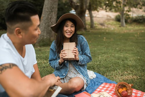 亚洲夫妇在野餐地与书上 · 免费素材图片