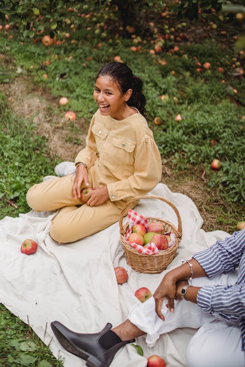 快乐的民族青少年女孩在花园里野餐时笑 · 免费素材图片