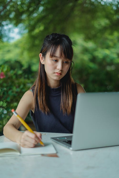 在看膝上型计算机的笔记薄的严肃的妇女文字 · 免费素材图片