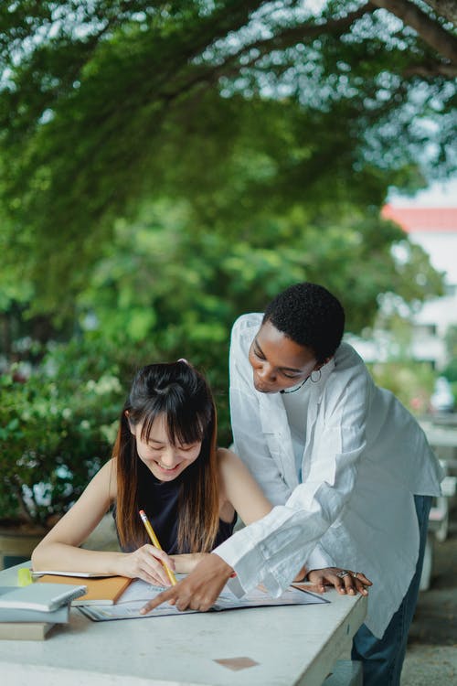 多种族的女学生为在公园里的考试做准备 · 免费素材图片