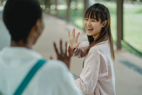 问候庄稼黑人女朋友的愉快的亚裔妇女在街道上 · 免费素材图片